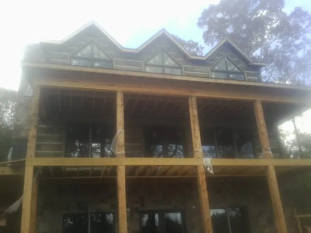 Dormers and porch framing on a large log home under construction — Roof Coating work by our crew in Kokomo