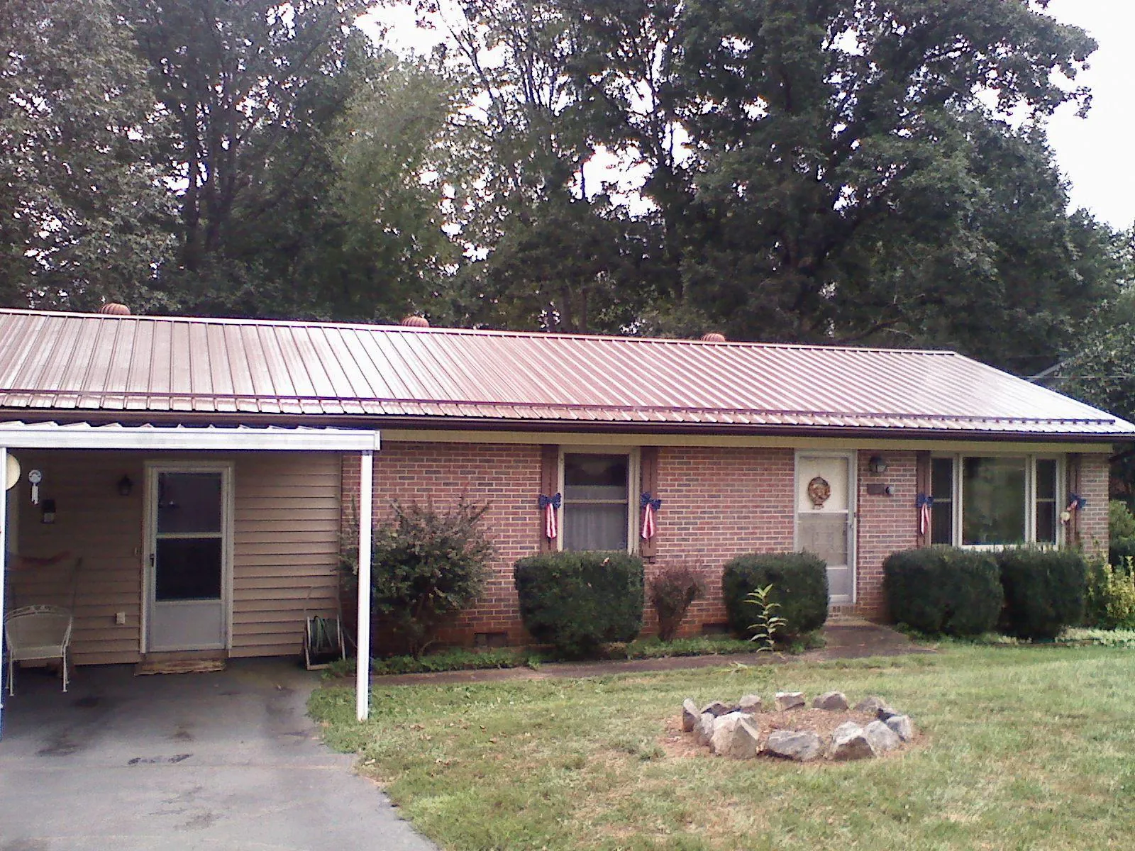 Bronze metal roof and carport on a brick ranch home — Roof Repair work by our crew in Kokomo