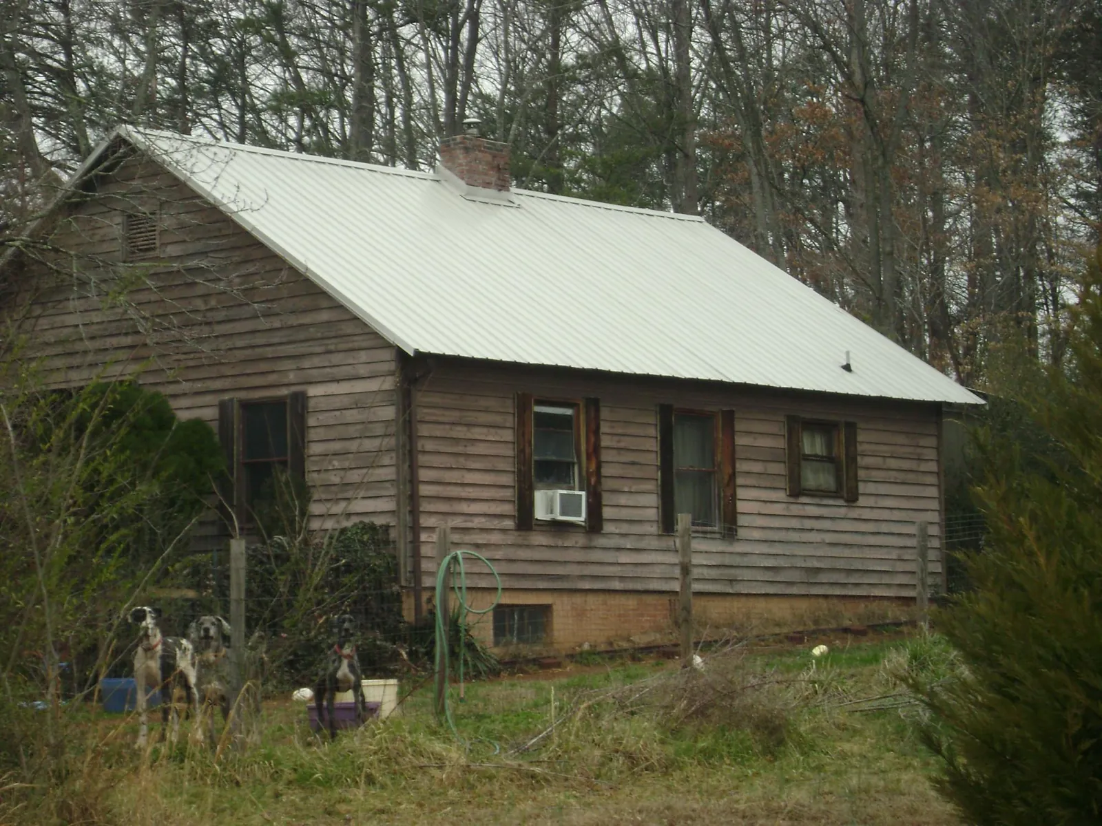 White metal roof on an old wood sided farmhouse, from a Metal Roof Installation job in Kokomo